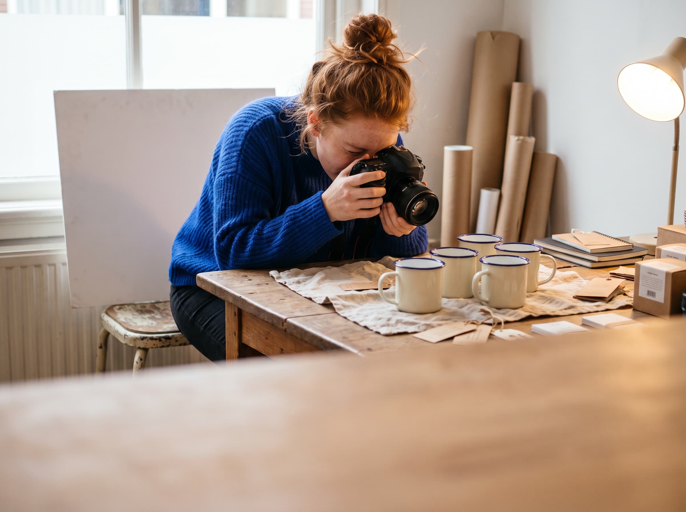 Shop owner photographing enamel mugs for the webshop